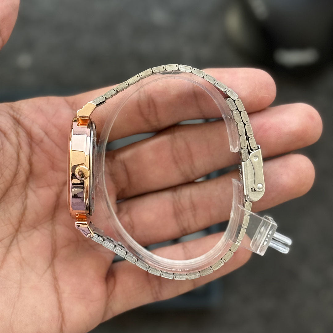 Foto real del costado de un reloj Currean 9081 para dama con correa plateada y caja con bordes oro rosa