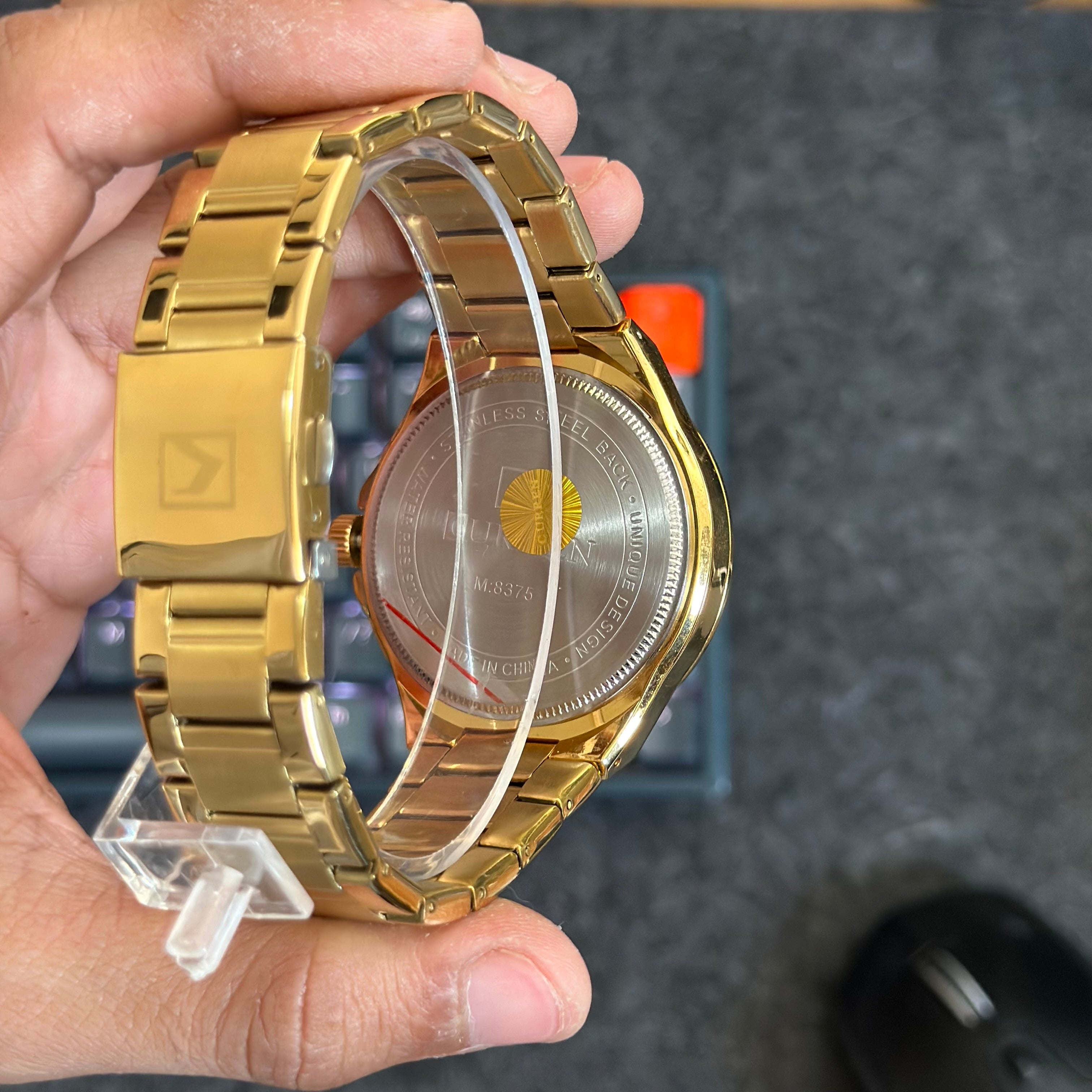 Foto real de la parte trasera de la caja de un reloj Curren 8375 dorado para hombre