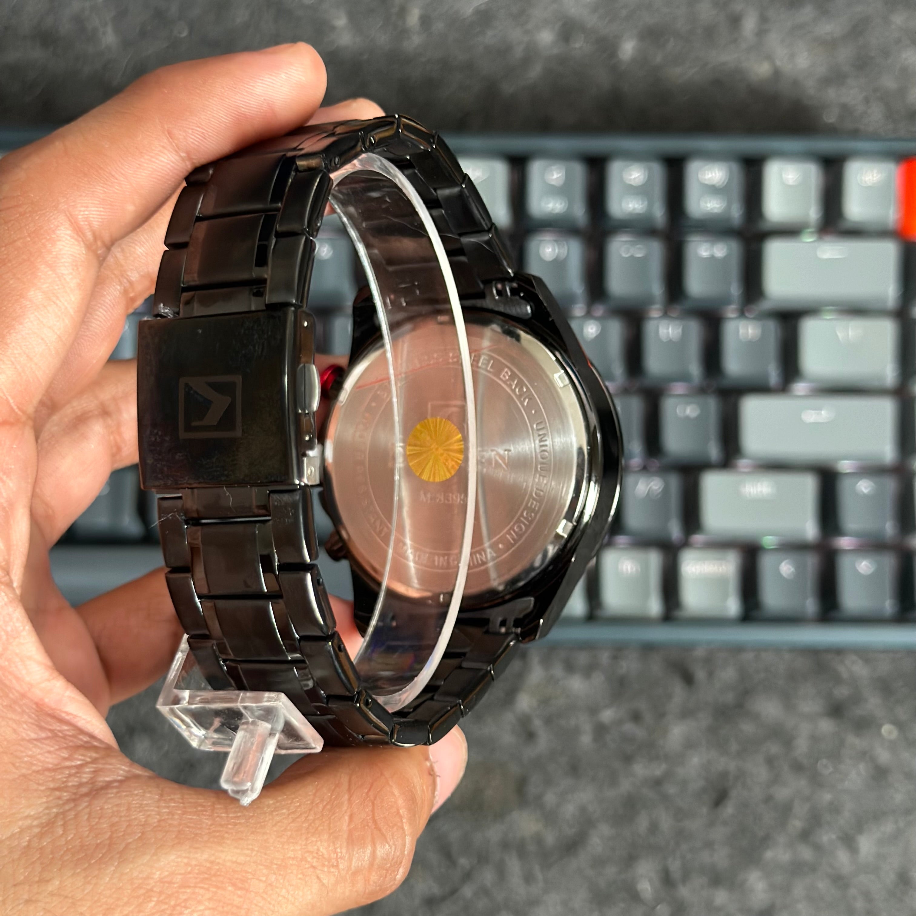 Foto real de la parte trasera interna de un reloj metálico deportivo para hombre Curren 8395 color negro con detalles beige