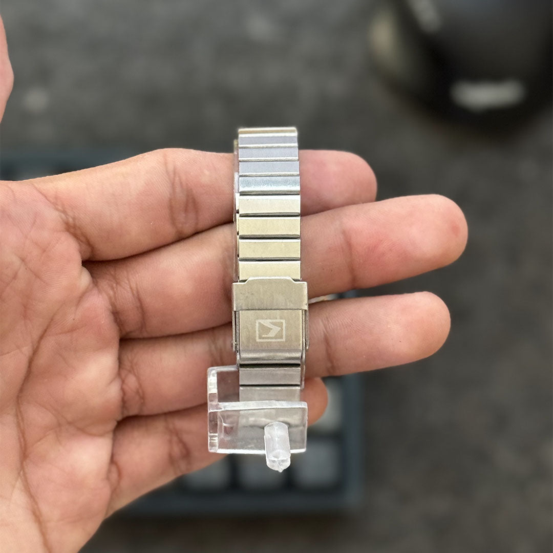 Foto real de la parte trasera de un reloj Currean 9081 para dama con correa plateada y caja con bordes oro rosa
